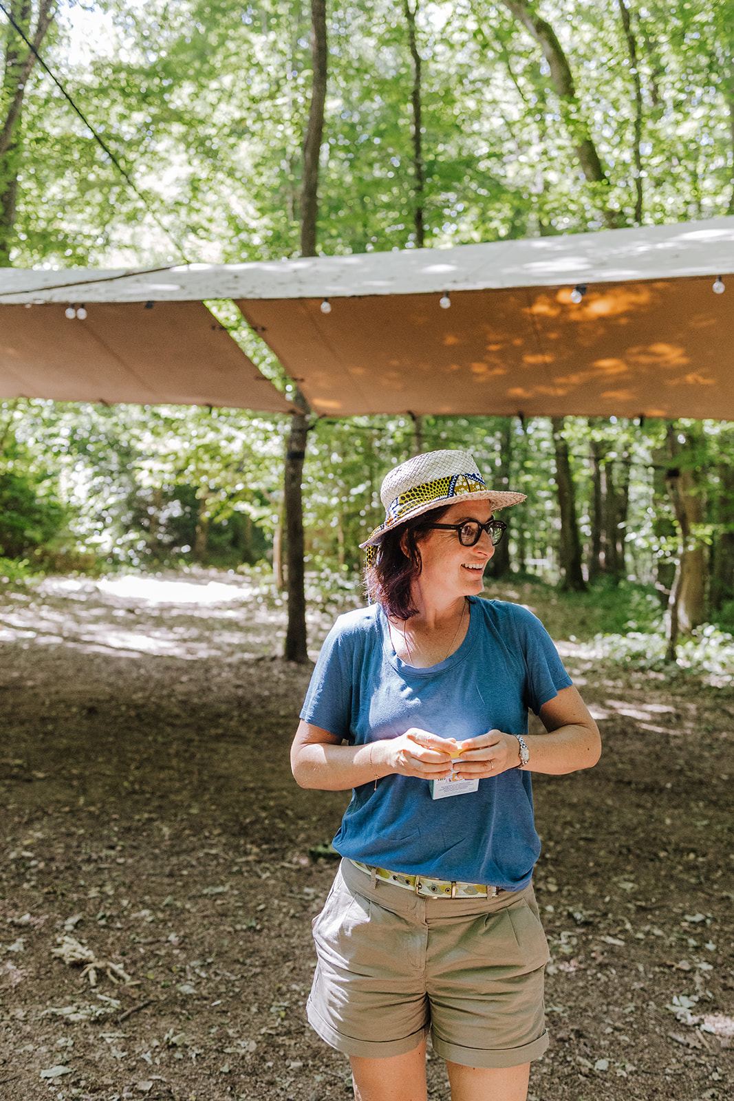 Anne-Laure sous un abri en forêt, carnet à la main